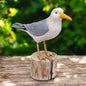 a bird sitting on top of a wooden stump